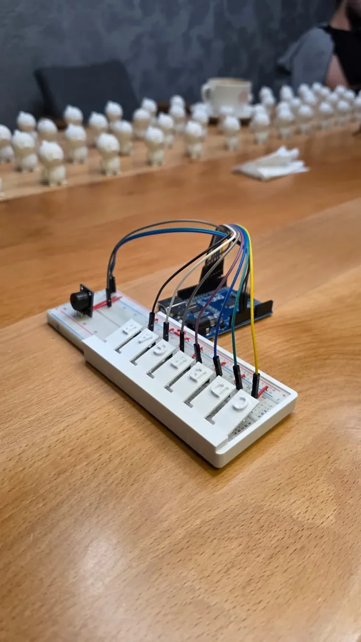 RoboKey'in fotoğrafı: yedi tuşlu klavye, breadboard ve Arduino kartı, masada